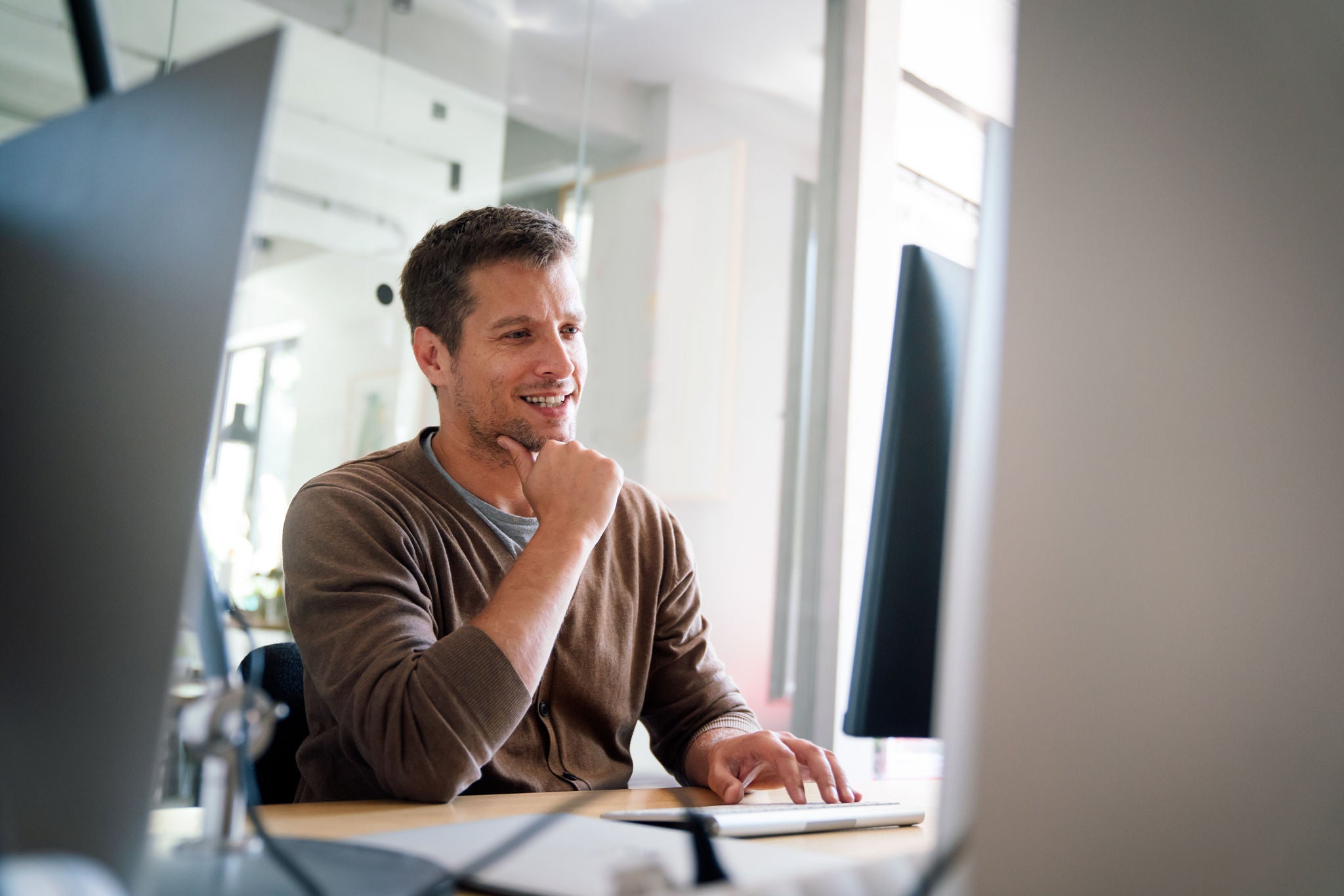 Programmer, web developer, designer working at office comparing mobile and desktop website versions. Business people concept.